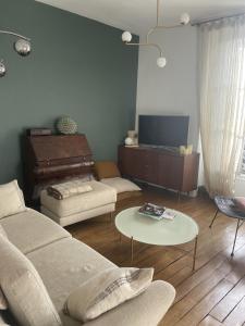 sala de estar con sofá y mesa en Appartement cosy, en Le Perreux-Sur-Marne