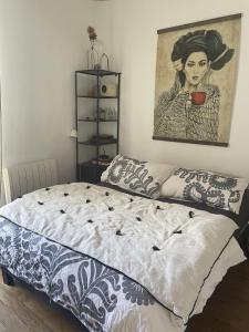 1 cama en un dormitorio con una pintura en la pared en Appartement cosy, en Le Perreux-Sur-Marne