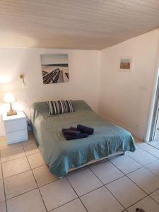 a bedroom with a bed and a tiled floor at chalet la rose des sables in Labenne
