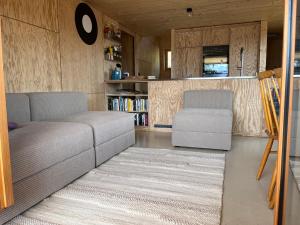 ein Wohnzimmer mit einem Sofa und einem Stuhl in der Unterkunft Sunnehuesli in Braunwald