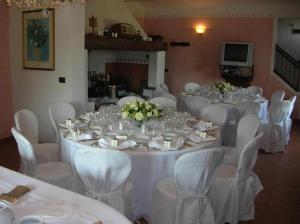 een lange tafel met witte tafels en witte stoelen bij Villa Bottaio in Foiano della Chiana