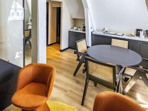 comedor con mesa y sillas en Grand Hotel La Cloche Dijon - MGallery en Dijon