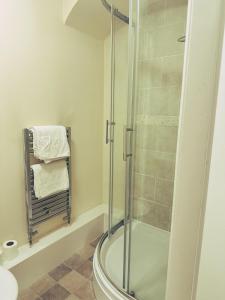 a bathroom with a shower with a glass door at Castle View, 96 Friar Lane in Nottingham