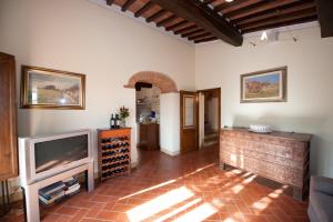 ein Wohnzimmer mit einem TV und einem Backsteinboden in der Unterkunft Lungagnana Apartment Terra in Nebbiano