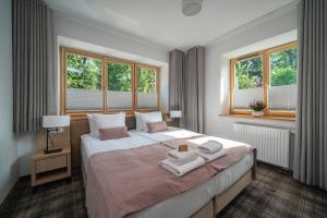 a bedroom with a large bed with towels on it at Willa Pod Kolejką in Szczawnica