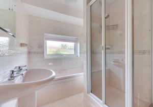 uma casa de banho branca com um lavatório e um chuveiro em Willow House em Halesworth