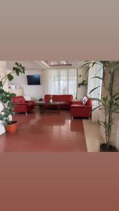 - un salon avec des canapés rouges et une télévision dans l'établissement Hotel Elyon Dej, à Dej