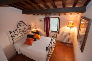 um quarto com uma cama branca e almofadas laranja em Lungagnana Apartment Cielo em Nebbiano