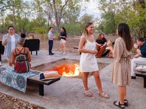 un groupe de personnes debout autour d'un foyer extérieur dans l'établissement Mercure Kakadu Crocodile, à Jabiru