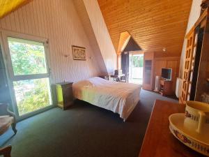 um quarto com uma cama e uma grande janela em Ref 067 Maison proche golfe du Morbihan pour six à huit personnes à louer pour les vacances em Arzon