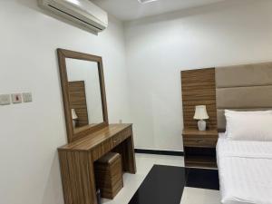 1 dormitorio con espejo grande y cama en الريف بارك للشقق المخدومة, en Al Majmaah