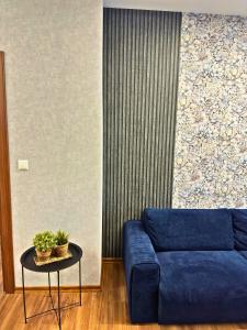 a living room with a blue couch and a table at WEST POINT DELUXE APARTMENT in Plovdiv