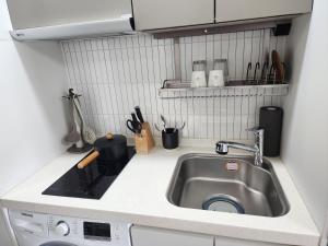 束草市的住宿－Sokcho Summitbay 1402 "Ocean View"，厨房柜台设有水槽和炉灶。