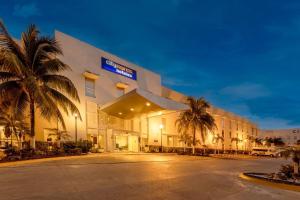 a hotel building with palm trees in front of it at City Express by Marriott Tuxtla Gutiérrez in Tuxtla Gutiérrez