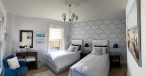 a bedroom with two beds and a chandelier at Radharc Na Cuilcagh in Enniskillen