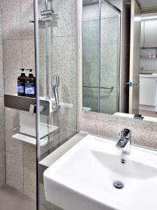 a bathroom with a white sink and a shower at Sokcho Summitbay 1402 "Ocean View" in Sokcho