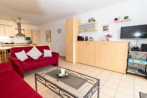 a living room with a red couch and a tv at Nordseeblick 5 in Cuxhaven