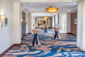 a hallway with three tables in a hotel lobby at Hilton Arlington in Arlington