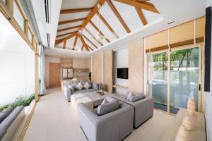 uma sala de estar com um sofá e uma mesa em Himmapana Villas - SHA Extra Plus em Kamala Beach