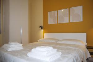 una pila de toallas sentadas encima de una cama en Le Sere, en Reggio Calabria