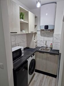 a white kitchen with a sink and a microwave at Sco Studio in Galaţi