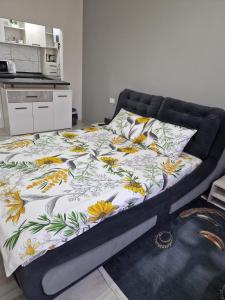 a bed with a floral comforter in a bedroom at Sco Studio in Galaţi
