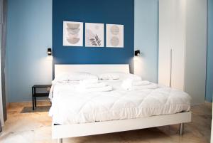 a bedroom with a white bed with blue walls at Le Sere in Reggio Calabria +49 photos