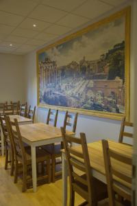 a dining room with tables and chairs and a painting on the wall at Boutique Hostel Livia in Metković