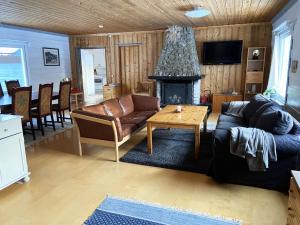 un soggiorno con divano e tavolo di Cozy cottage on a large natural plot in lovely Harjedalen a Vemdalen