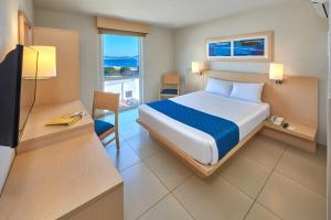 Dormitorio con cama, escritorio y TV en City Express by Marriott Xalapa en Xalapa