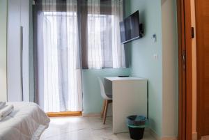 a bedroom with a bed and a desk and a television at Le Sere in Reggio di Calabria