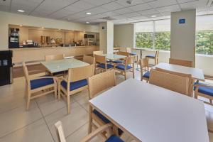 un restaurant avec des tables, des chaises et un comptoir dans l'établissement City Express by Marriott Xalapa, à Xalapa