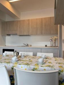 cocina con mesa y mantel con motivos florales en Residenze Ariston - centralissimi - Narramondo Villas en Giulianova