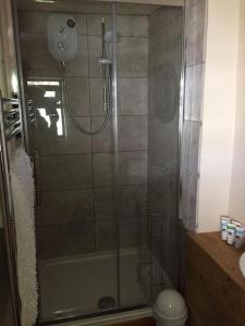 a shower with a glass door in a bathroom at Homer Old Spot in Marytavy
