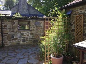 a garden with a wooden gate and a building at Homer Old Spot in Marytavy