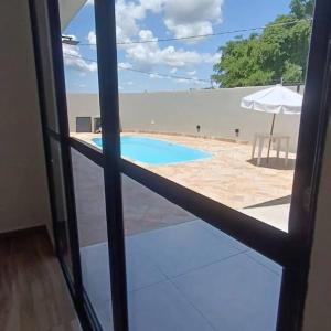 uma vista para uma piscina a partir de uma janela em Recanto Shalom em São Carlos