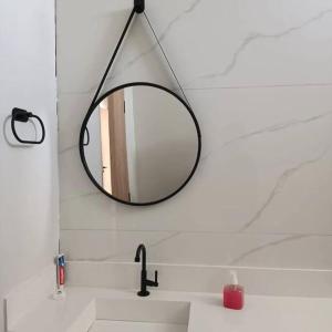 a bathroom sink with a mirror on the wall at Recanto Shalom 3 dormitórios in São Carlos