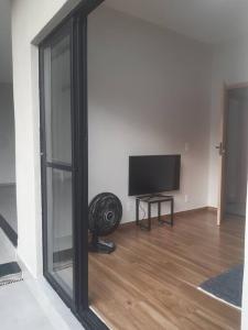 a living room with a mirror and a television at Recanto Shalom in São Carlos