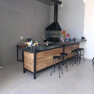 a kitchen with a counter with bar stools at Recanto Shalom in São Carlos
