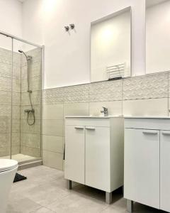 La salle de bains est pourvue d'un lavabo, de toilettes et d'une douche. dans l'établissement Casa Bandi, à Madrid