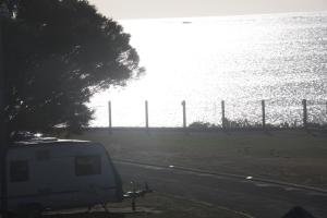a white van parked next to a body of water at Sea Vu Caravan Park in Robe