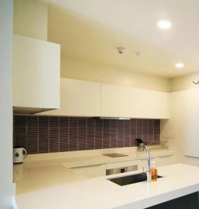 a kitchen with white cabinets and a sink at Tropicana The Residence KLCC in Kuala Lumpur