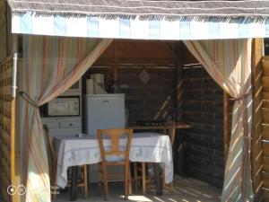 a kitchen with a table and chairs under an awning at Yourte et nature in Magnien
