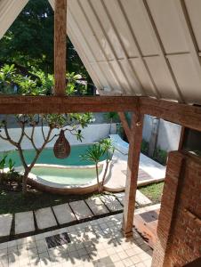 einen Pavillon mit einem Bett und einem Pool in der Unterkunft Amara Villa in Gili Trawangan