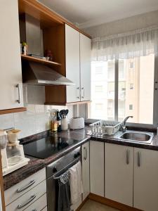 uma cozinha com armários brancos, um lavatório e uma janela em Los Urrutias, Murcia, Mar Menor em Los Urrutias