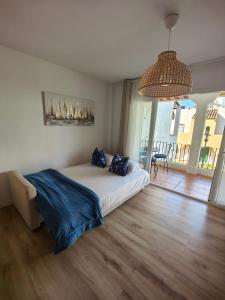 a bedroom with a bed and a large window at Renovated apartment on beachside with pool in Nerja