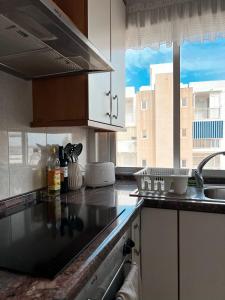 uma cozinha com um balcão com um lavatório e uma janela em Los Urrutias, Murcia, Mar Menor em Los Urrutias