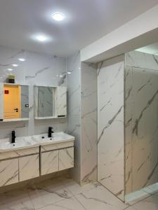 a bathroom with two sinks and two mirrors at Amman Trail Hostel in Amman