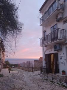 a white building with two balconies on a street at Dentro Scopello - Casa Vacanze in Scopello