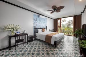 ein Schlafzimmer mit einem Bett und einem Tisch und einem Fenster in der Unterkunft La Vento Resort Ninh Bình in Ninh Bình